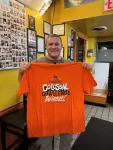 Proud winner of the Chick and Ruth's Colossal Food Challenge wearing the official orange finisher T-shirt.