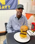 Customer taking on the 3lb Colossal Burger challenge at Chick and Ruth's Delly in Annapolis.